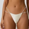 Bas de bikini string à double bretelle Mabe avec détails en perles, couleur blanc perle Bas de bikini string à double bretelle Mabe avec détails en perles, couleur blanc perle