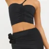 Haut asymétrique en jersey moulant avec détails roses de Tesia, couleur noir Haut asymétrique en jersey moulant avec détails roses de Tesia, couleur noir