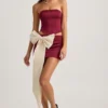 Mini-jupe taille basse Carola en satin avec nœud, couleur rouge vin Mini-jupe taille basse Carola en satin avec nœud, couleur rouge vin