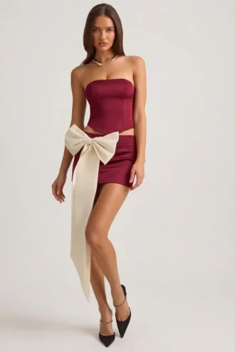 Mini-jupe taille basse Carola en satin avec nœud, couleur rouge vin