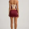Mini-jupe taille basse Carola en satin avec nœud, couleur rouge vin Mini-jupe taille basse Carola en satin avec nœud, couleur rouge vin