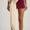 Mini-jupe taille basse Carola en satin avec nœud, couleur rouge vin Mini-jupe taille basse Carola en satin avec nœud, couleur rouge vin