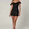 Mini-robe trapèze Jacira à lacets et ornements, en noir Mini-robe trapèze Jacira à lacets et ornements, en noir