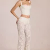 Pantalon évasé taille moyenne en dentelle transparente Calista, couleur ivoire Pantalon évasé taille moyenne en dentelle transparente Calista, couleur ivoire