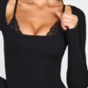 Robe courte Caris à manches longues en modal côtelé avec bretelles en dentelle, couleur noire Robe courte Caris à manches longues en modal côtelé avec bretelles en dentelle, couleur noire