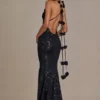 Robe longue noire à décolleté plongeant et dos nu, ornée de paillettes Robe longue noire à décolleté plongeant et dos nu, ornée de paillettes